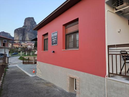 een rood gebouw met een berg op de achtergrond bij SOCRATES Ethnic and traditional Home in Kalabaka