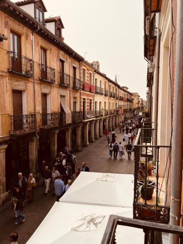 a group of people walking down a street at calle mayor in Alcalá de Henares