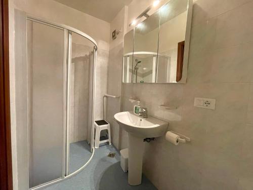 y baño blanco con lavabo y ducha. en Frontemare 6 posti letto + posto auto gratuito, en Bibione