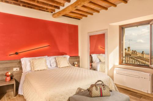 una camera rossa con letto e finestra di Palazzo Falcinelli Luxury Room in Montepulciano Center with Elevator a Montepulciano