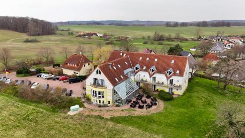 eine Luftansicht eines großen Hauses auf einem Feld in der Unterkunft Inselhotel kleiner Bodden in Buschvitz