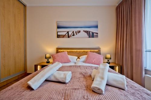 a bedroom with a large bed with two pillows at Apartament Orlando w Porto Łeba 350m od morza in Łeba