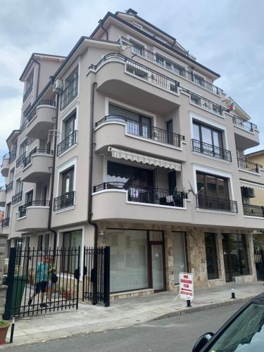 Un grand bâtiment blanc avec balcon se trouve dans une rue. dans l'établissement Sea View Rooms Briz, à Nessebar