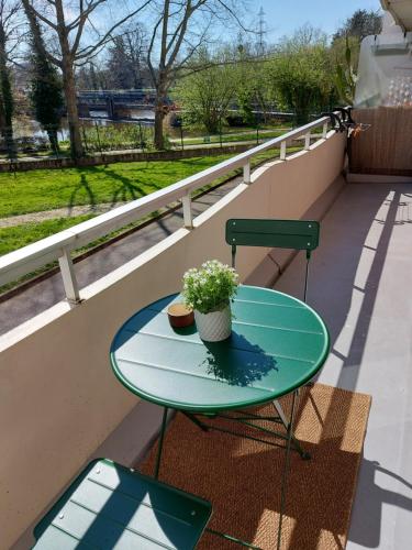 d'une table verte et d'une chaise sur un balcon. dans l'établissement Appartement Rennes stade parking gratuit, à Rennes