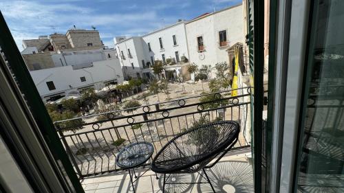 einen Balkon mit 2 Stühlen und Stadtblick in der Unterkunft Residenza Garibaldi in Monopoli