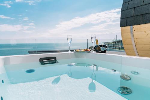 a bath tub with a view of the ocean at Akrotiri Olympus Luxury Suites - Adults Only in Plaka Litochorou