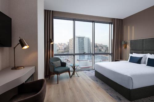 ein Hotelzimmer mit einem Bett und einem großen Fenster in der Unterkunft Delta Hotels by Marriott Istanbul Kagithane in Istanbul