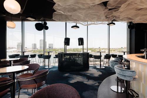 een restaurant met tafels en stoelen en grote ramen bij DoubleTree by Hilton Amsterdam Centraal Station in Amsterdam