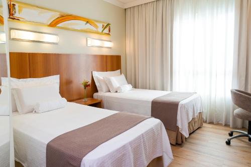 Giường trong phòng chung tại Bourbon Convention Hotel Joinville