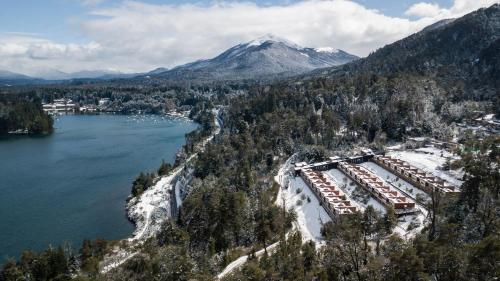 een luchtzicht op een resort naast een meer en een berg bij Montaña Resort in Villa La Angostura