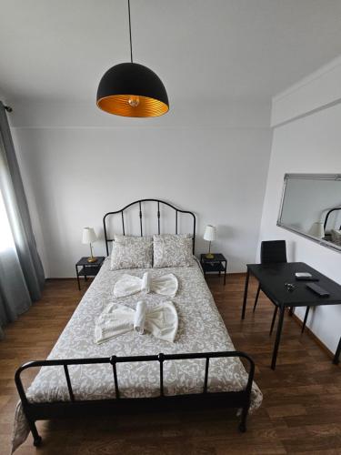 una camera da letto con un letto con una lampada e un tavolo di VILLAGE SINTRA gh a Sintra