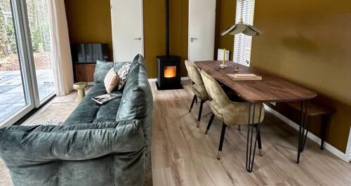 Summ Lodge - luxe boutique lodge Veluwe في نونسبيت: غرفة معيشة مع أريكة وطاولة خشبية