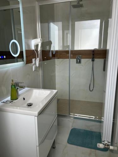 a white bathroom with a shower and a sink at Casa Avram in Suceviţa