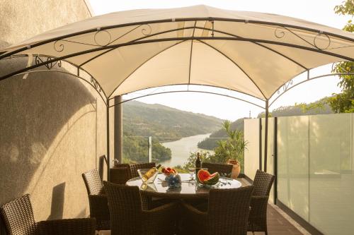 un tavolo sotto un ombrellone su un balcone con vista di Quinta Flor de Lis, Gerês a Vieira do Minho