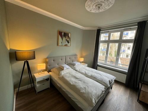 - une chambre avec un lit avec deux lampes et deux fenêtres dans l'établissement Art Apartments, à Hambourg