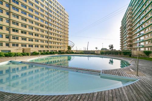 a large swimming pool in front of two tall buildings at Luxury Living by the Sea Matosinhos Marvel in Matosinhos