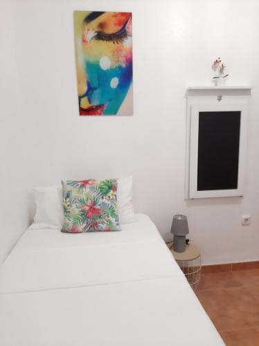 un letto bianco con un cuscino sopra di Habitación Avileña Tropical en Aguadulce a Almería