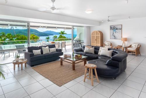 ein Wohnzimmer mit 2 Sofas und einem Tisch in der Unterkunft Bella Vista East 4 Oceanview, Golf Buggy, Valet Service & Shared Pool in Hamilton Island