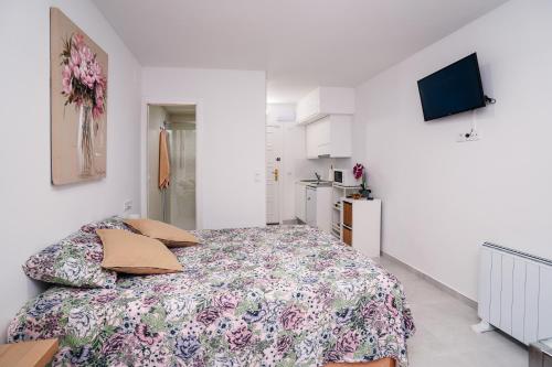 een slaapkamer met een bed met een bloemenbed bij Rio Mar Studio reformado marzo 2024 in Empuriabrava