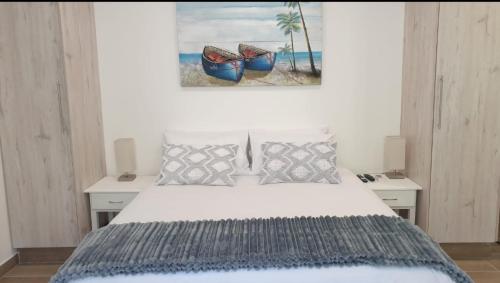 een slaapkamer met een bed en een schilderij aan de muur bij Avonlea Guest House in Kloof