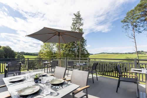 a patio with tables and chairs and an umbrella at zum Sausaler - Boutique Hotel-Pension Südsteiermark in Sankt Nikolai im Sausal