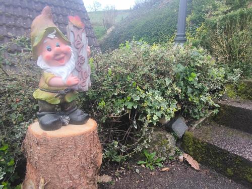 une statue d'un enfant assis sur une mâchoire d'arbre dans l'établissement Ferienhaus The Himmelsteig, à Sasbachwalden