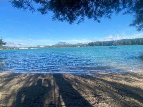 une ombre d’une personne sur la rive d’un lac dans l'établissement Faakersee Seahouse mit Privat Strand -Only Sa-Sa, à Faak am See