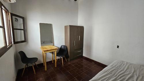 a bedroom with a desk and two chairs and a dresser at La Merced in Salta