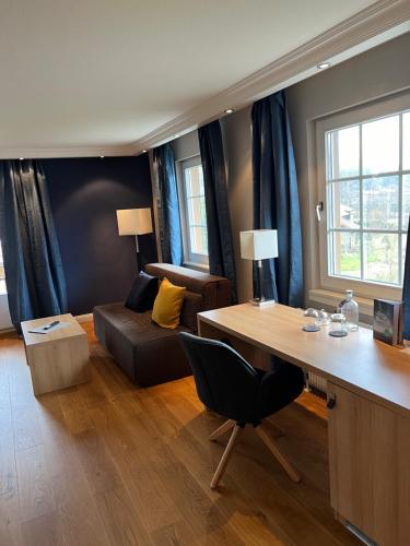 een woonkamer met een bureau en een bank bij Hotel Lamm in Baiersbronn