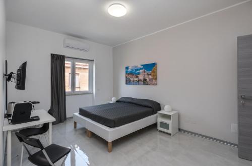 a bedroom with a bed and a desk and a window at Travelershome Ciampino Airport GuestHouse 600m to Airport in Ciampino