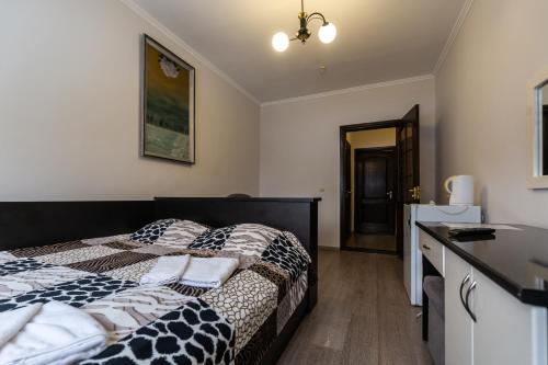 a bedroom with a bed with a black and white comforter at Алексік in Truskavets