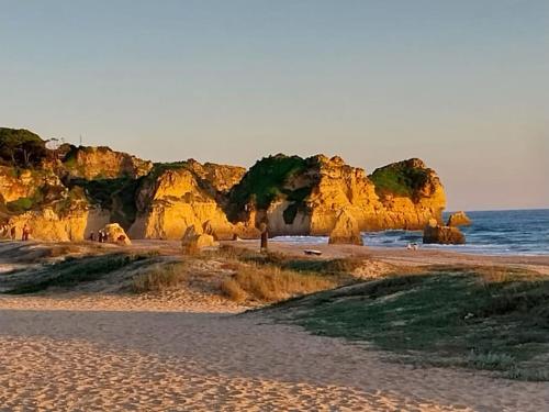 a beach with some rocks in the water at MAREA Algarve - Sea view sunny apartment in Alvor in Alvor