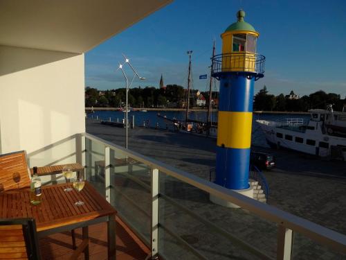 un faro en un balcón con mesa y banco en Apartmenthaus Hafenspitze Ap 10 - "Borbyblick" - Blickrichtung Hafen und offene See - a72335, en Eckernförde