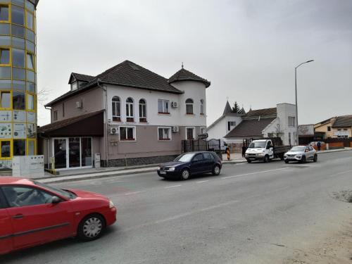 a group of cars driving down a street with buildings at Pensiunea Crown Royal in Alba Iulia