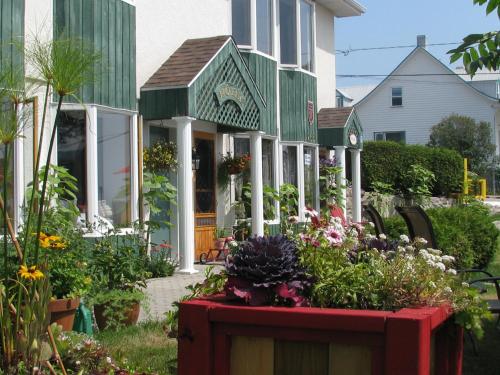 una casa con un mazzo di fiori in giardino di Hotel Le Pionnier a Tadoussac