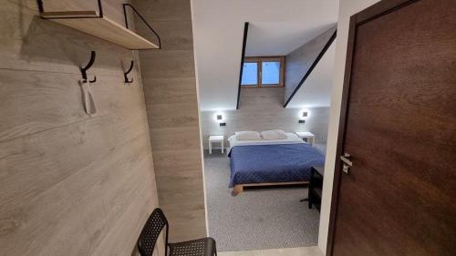 um quarto com uma cama azul e uma janela em Central Hotel em Lviv