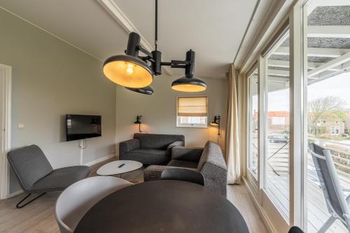 salon z kanapą, krzesłami i telewizorem w obiekcie Zeayou Zeeland - Appartementen Beatrixstraat 29 w mieście Domburg