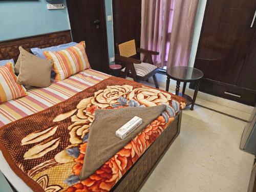 een bed met een deken met een afstandsbediening erop bij Sky Bloom Luxury Homestay in New Delhi