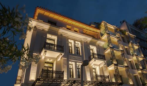 - un grand bâtiment blanc avec balcon et éclairage dans l'établissement The Residence Aiolou Hotel & Spa, à Athènes