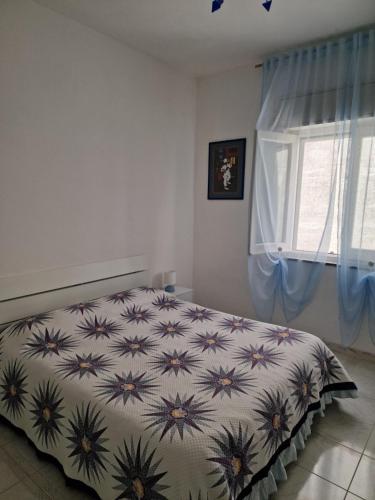 a bedroom with a bed with a floral bedspread and a window at Agriturismo Fuoco D'Amalfi Villa Iazzetta in Amalfi