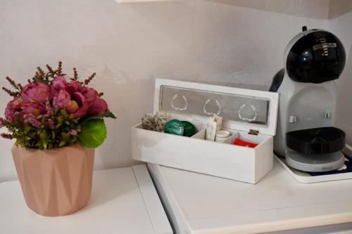 a vase of flowers sitting on a counter next to a box at Casa Donna di Cuori in Fiumicino