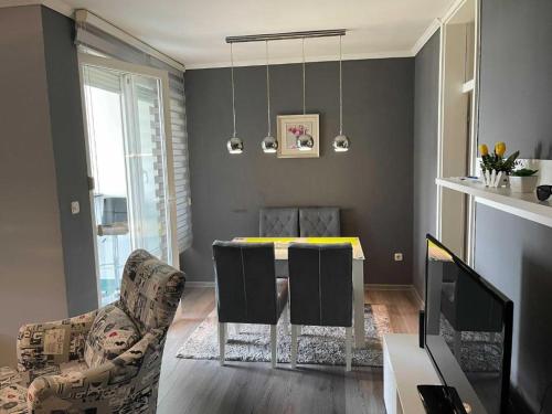 uma sala de estar com uma mesa de jantar e cadeiras em Apartment Paradise em Tuzla