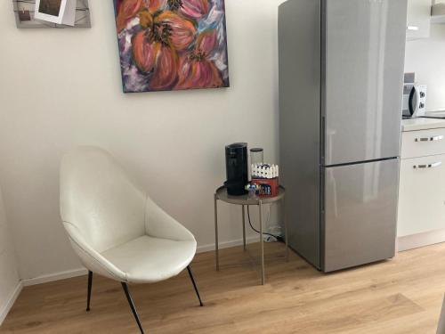 uma cadeira branca e uma mesa numa cozinha com um frigorífico em CASA NOVA Luxury Apartment Suite Fichi d'India em Nova Milanese