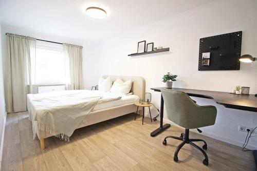 una camera con letto, scrivania e computer di Blossfeld-Apartments XL-Ferienwohnung Jena Zentrum, 2 Schlafzimmer, W-Lan, Waschtrockner, Smart-TV a Jena