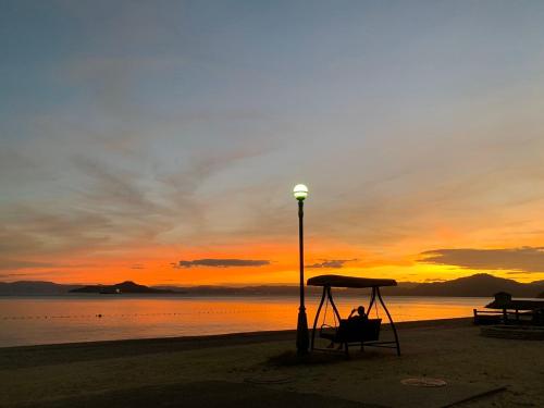 światło uliczne na plaży o zachodzie słońca w obiekcie Uminos Spa & Resort w mieście Etajima