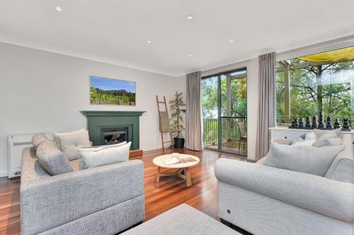 a living room with two couches and a fireplace at Villa 3br Chardonnay Villa located within Cypress Lakes Resort in Pokolbin