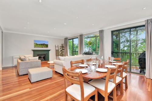 a dining room and living room with a table and chairs at Villa 3br Chardonnay Villa located within Cypress Lakes Resort in Pokolbin