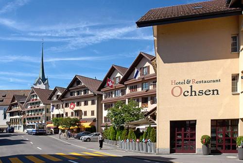 un edificio con un letrero al lado de una calle en Hotel Ochsen, en Menzingen