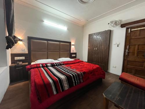 a bedroom with a large bed with a red blanket at Hotel Premier Mall Road Manali in Manāli