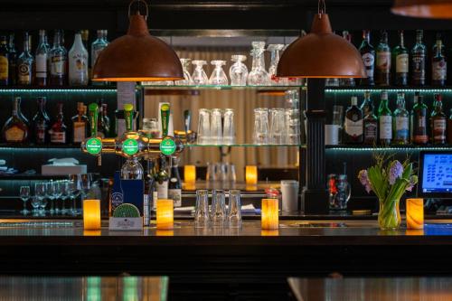 un bar con copas y botellas de alcohol en Hotel Royal, en Noordwijk